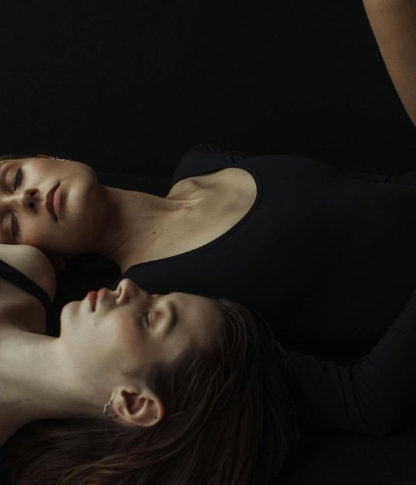 Woman in a graceful yoga pose with calm, plaster-like background.
